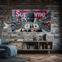 Tabloul cu bărbatul cu cagulă și bancnota de un dolar, pe un fundal urban colorat, este expus într-un interior modern, deasupra unei console din lemn cu o vază și o lumânare, Papilora.