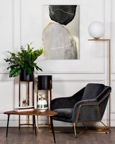 Tabloul abstract cu forme negre și gri, subliniate cu auriu, este agățat într-un interior modern și elegant, deasupra unei console din lemn, decorată cu o vază și o lumânare, Papilora.