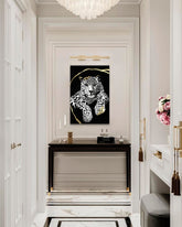 Tabloul cu leopard alb-negru și auriu este agățat într-un interior modern și elegant, deasupra unei console din lemn cu o vază și o lumânare, Papilora.