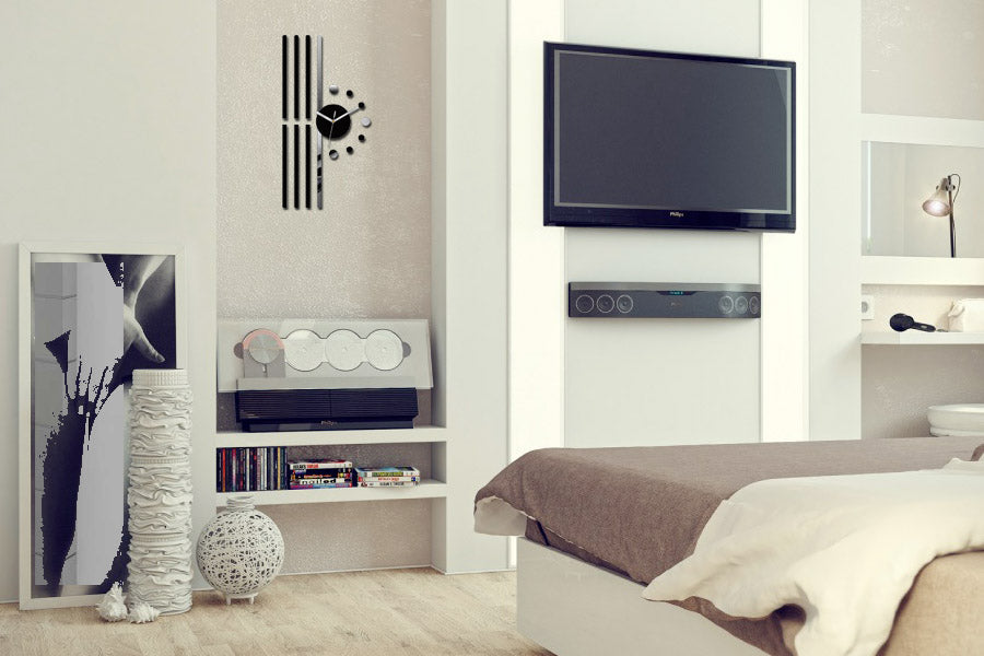 Ceasul de perete modern, cu un cadran negru și linii verticale, este agățat într-un interior stilat, deasupra unei console albe cu decorațiuni, Papilora.