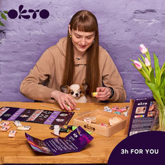 O cutie de lemn cu flori artificiale colorate, albe, roz și albastre, pentru un set de artă senzorială, așezată pe o masă modernă din lemn, Papilora.