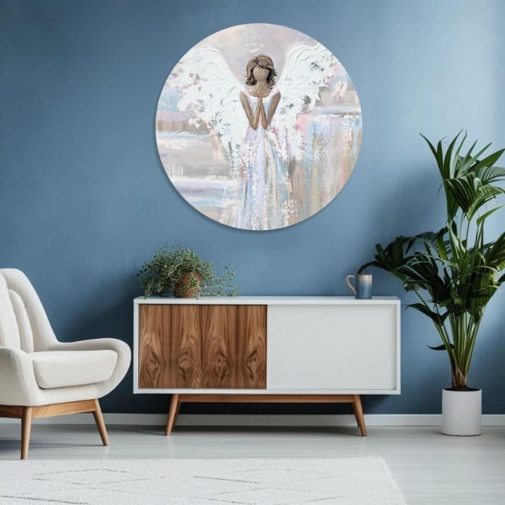 Tabloul cu îngerul în rugăciune, cu aripi albe și accente aurii, este agățat într-un interior modern, deasupra unei console din lemn cu o vază și o lumânare, Papilora.