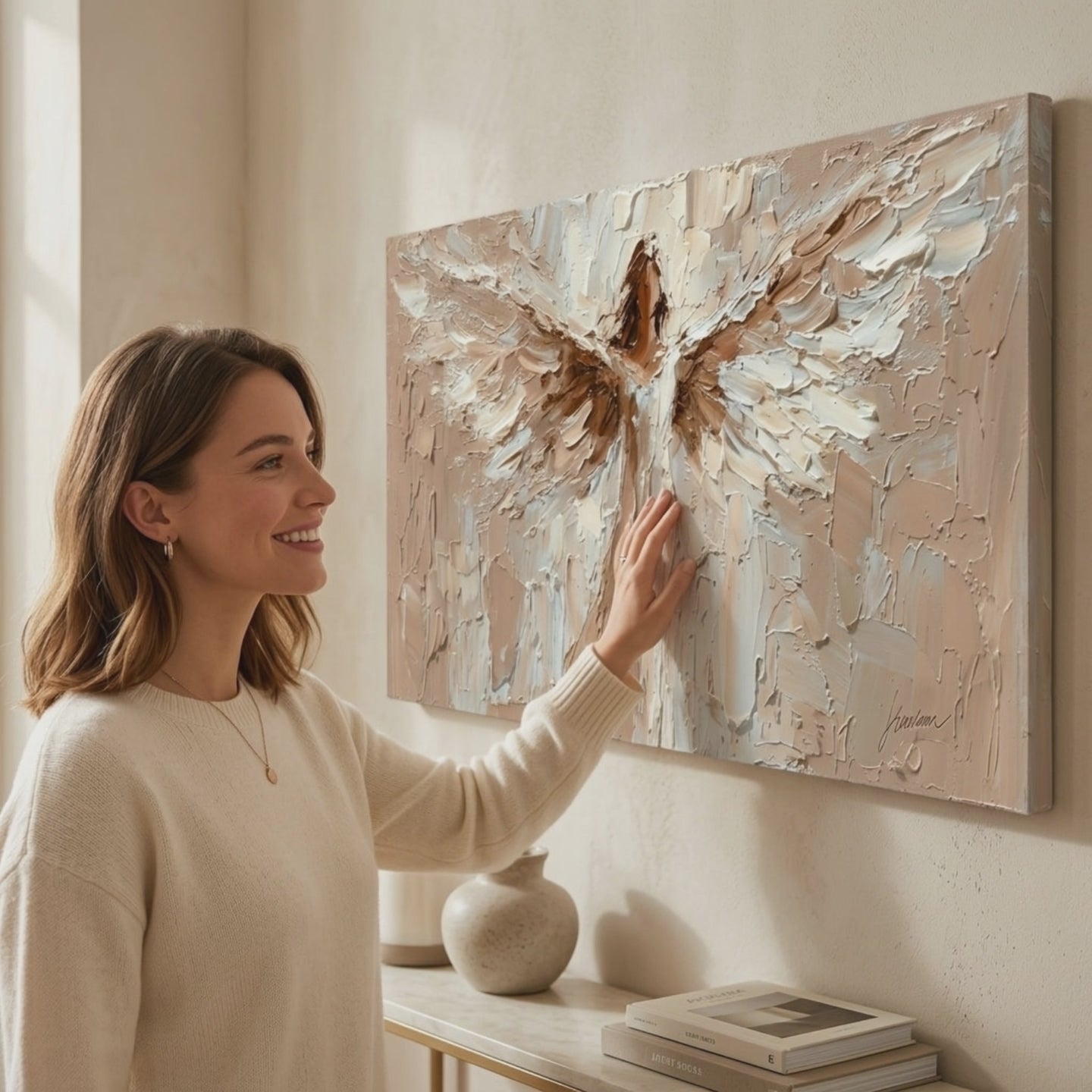Tablou de perete de înger Îmbrățișare divină – finisată de mâna artistului. Tablou premium pictat cu acrilic, decor modern de perete pentru sufragerie, o femeie admiră opera într-un interior stilat luminos. Papilora Premium Art (XOGMDPA253E1).