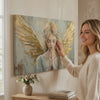 Tablouri de îngeri Rugăciunea de dimineață – finisată de mâna artistului. Tablou premium pictat cu acrilic, decor modern de perete pentru sufragerie, o femeie admiră opera într-un interior stilat luminos. Papilora Premium Art (XOGMDPA158E1).