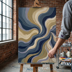 Artistă în atelierul Papilora lângă un șevalet cu un tablou abstract cu valuri și flux, lumină naturală de la fereastră.