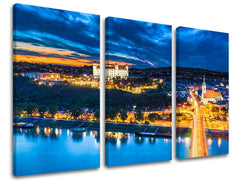 Clasic tablou pe pânză cu motivul SLOVACIA, castel, râu, pod, apus de soare în albastru-auriu nuanțe, atmosferă liniștită, viață urbană, execuție cu trei panouri – principală